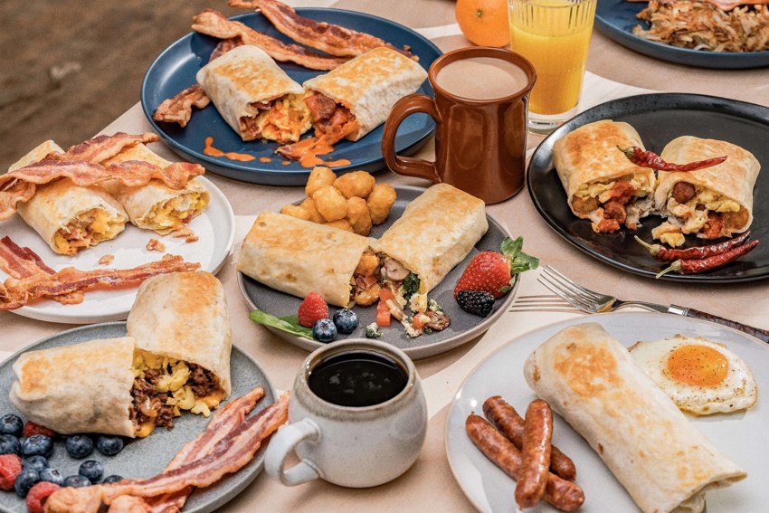 Breakfast burritos and bowls with coffee and orange juice